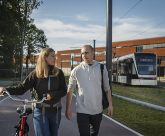 Studerende med cykel ved Letbanen ved SDU Odense